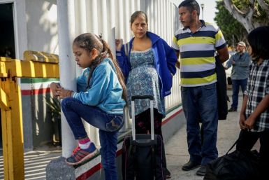 Migrants from Honduras wait in line at the Mexico-United States border crossing in Tijuana, Mexico on September 12, 2019