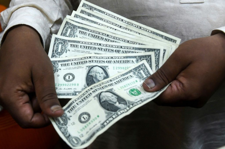 A Pakistani man counts US dollars at the currency exchange place in Lahore on May 16, 2019; meanwhile, gas stations in Lebanon are paid by customers in Lebanese pounds but must pay suppliers in US dollars