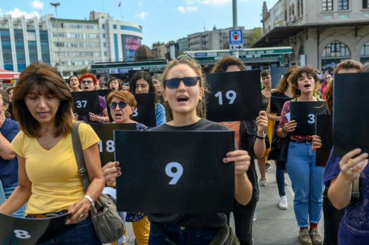Women held signs with different numbers signifying some of the victims killed this year