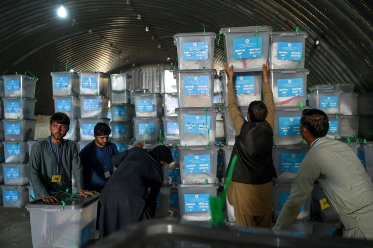 Independent Election Commission workers place ballot boxes to be taken to a counting centre at a warehouse the day after Afghanistan held presidential elections