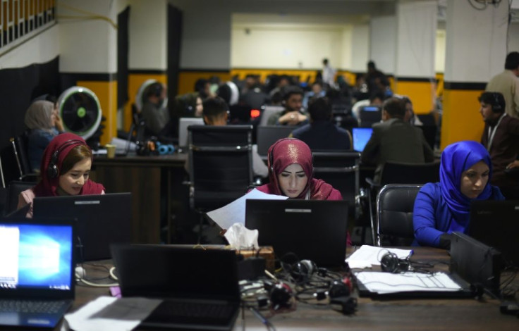 Members of presidential candidate Ashraf Ghani's campaign team answer phone calls at his headquarters in Kabul. His main rival, Abdullah Abdullah, has claimed victory in the vote, even though official results are not due for weeks