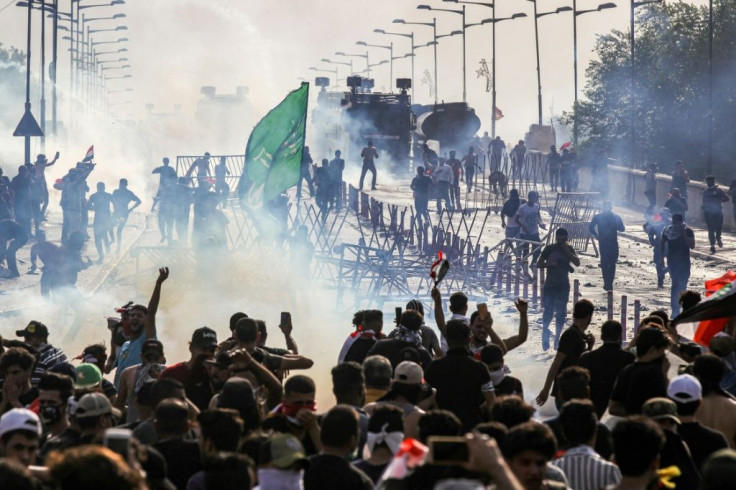 Protesters clash with Iraqi anti-riot police on a bridge leading to the capital's Green Zone during a demonstration against state corruption and poor services
