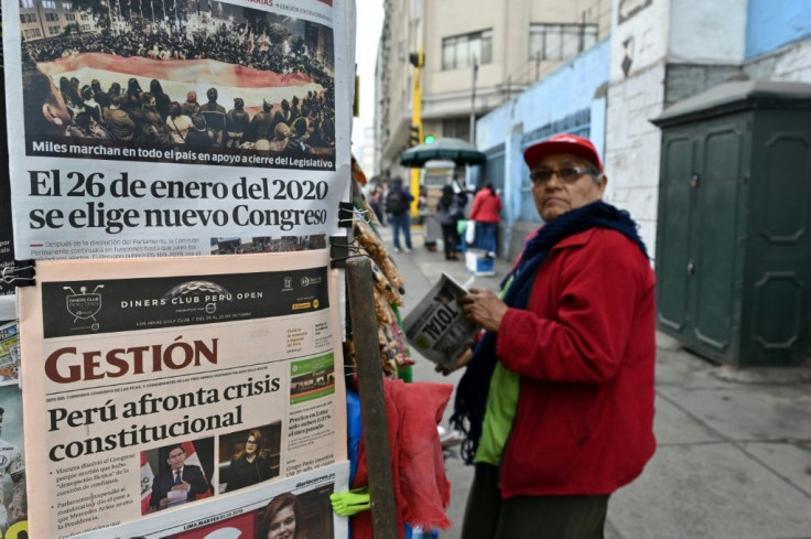A man stands at a kiosk displaying front pages of newspapers in Lima, a day after Presiden Martin Vizcarra dissolved the congress