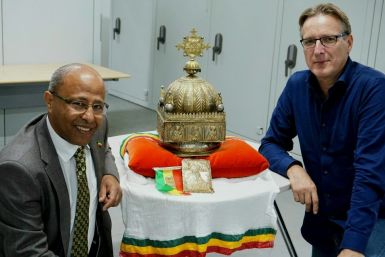The ornate gilded copper crown, featuring images of Jesus and the Apostles, was unearthed after refugee-turned-Dutch-citizen Sirak Asfaw (L) contacted Dutch 'art detective' Arthur Brand (R)