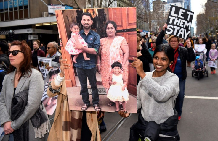 Protesters hold up placards in Melbourne during a rally in support of the Tamil refugee family