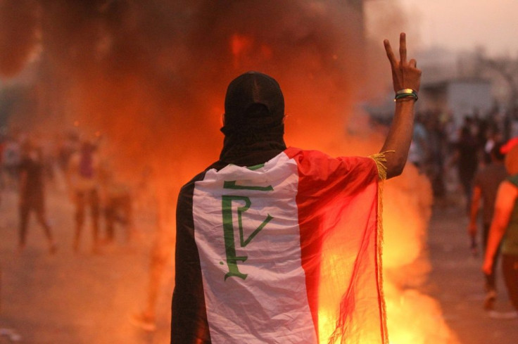 An Iraqi protester gestures the v-sign during a demonstration against state corruption, failing public services and unemployment at a square in Baghdad