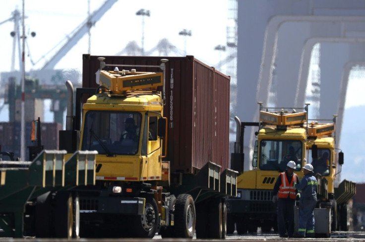 The transportation sector reported slower deliveries in September. Trucks move containers as they are offloaded from a ship at the Port of Oakland in September 2019 in California.