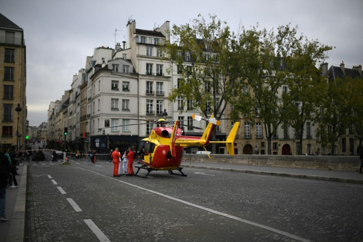 An ambulence helicopter waited on a bridge Thursday near the Paris police headquarters, after an employee wielding a knife killed four officers.