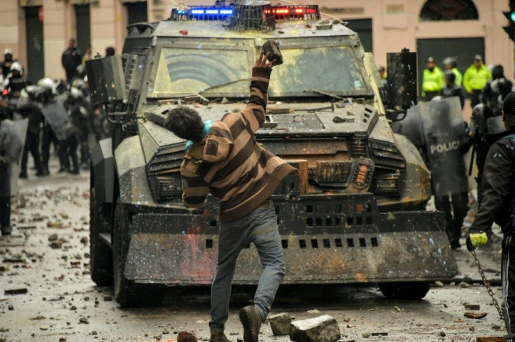 A demonstrator clashes with riot police during a transport strike against the economic policies of President Lenin Moreno's government