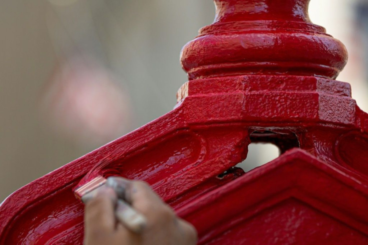 Painter Gerson Gomez, working with artist Charles Bergen (not pictured), colors an old call box formerly used to alert firefighters in Washington