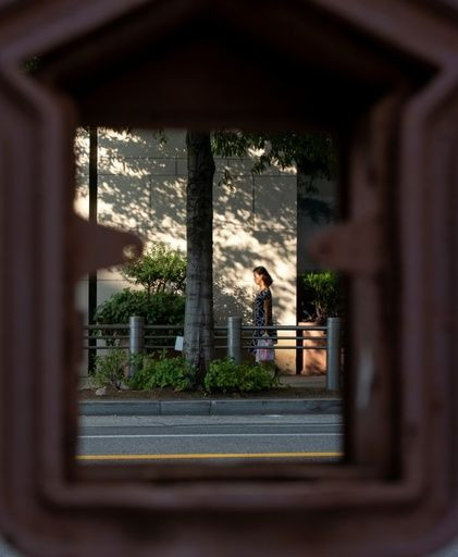 A woman is seen through a decaying old call box formerly used to alert firefighters in Washington's Foggy Bottom district