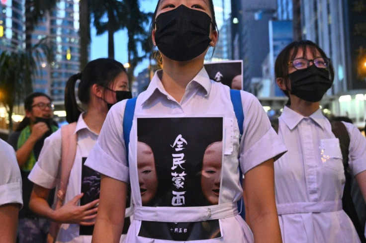 High school students chanted slogans and stuck posters reading "all people masked" on their uniforms as they gathered in the heart of Hong Kong's commercial district