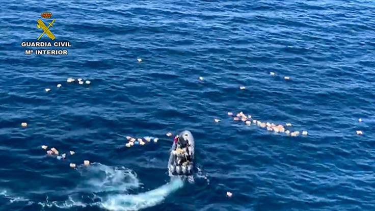 This handout picture released by the Spanish Guardia Civil shows a speedboat surrounded by bundles of drugs in the sea, after a police high-speed chase with drug-smugglers, off the coast of Mijas, Malaga, southern Spain