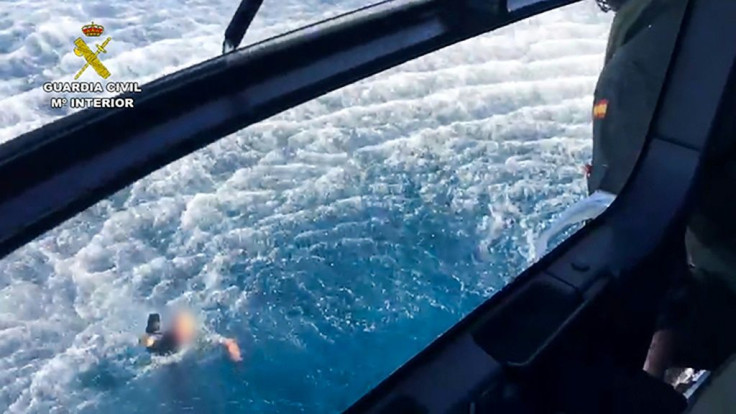 This handout picture released by the Spanish Guardia Civil shows a police officer swimming back to the police helicopter, after three Spanish police officers who were thrown into the sea when their boat crashed during a high-speed chase