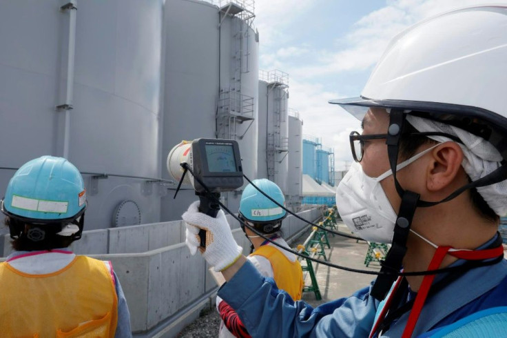 Staff measure radiation levels around the storage tanks of radiation-contaminated water at the tsunami-crippled Tokyo Electric Power Company (TEPCO) Fukushima Dai-ichi nuclear power plant in Japan