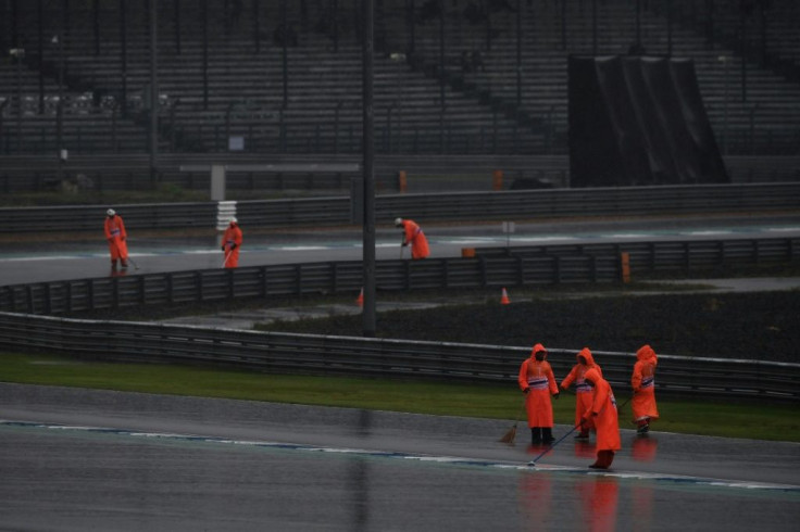 Workers clear the track after the Thai MotoGP qualifying session was delayed due to heavy rain