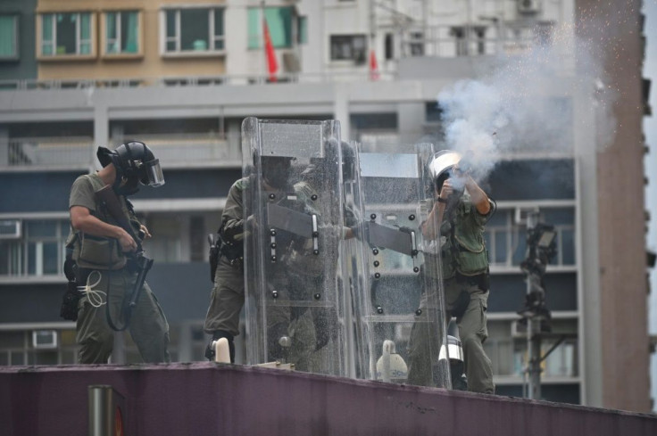 Police fire tear gas from the roof of Mongkok police station toward protesters