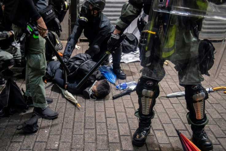 A protester (C) is detained by police during clashes in the Wan Chai district in Hong Kong