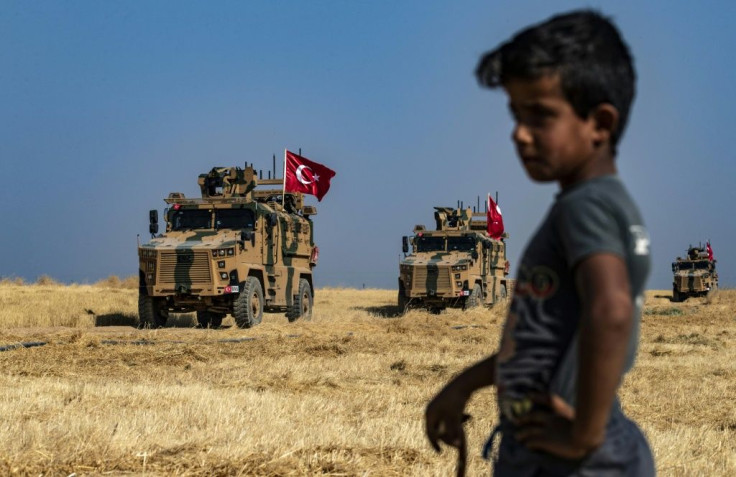 Turkish military vehicles take part in a joint patrol with US forces on the outskirts of Syria's Kurdish-controlled Tal Abyad on October 4, 2019