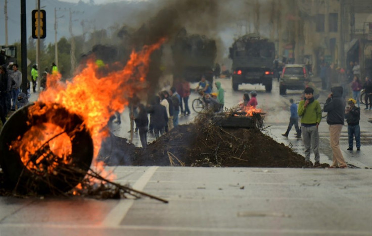 A tire burns at a barricade set by demonstrators in Quito on October 7, 2019 following days of protests against the sharp rise in fuel prices sparked by authorities' decision to scrap subsidies
