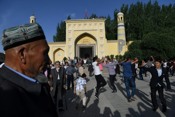 Uighur men dance before sightseers after Eid al-Fitr prayers in June 2019 in the Xinjiang city of Kashgar
