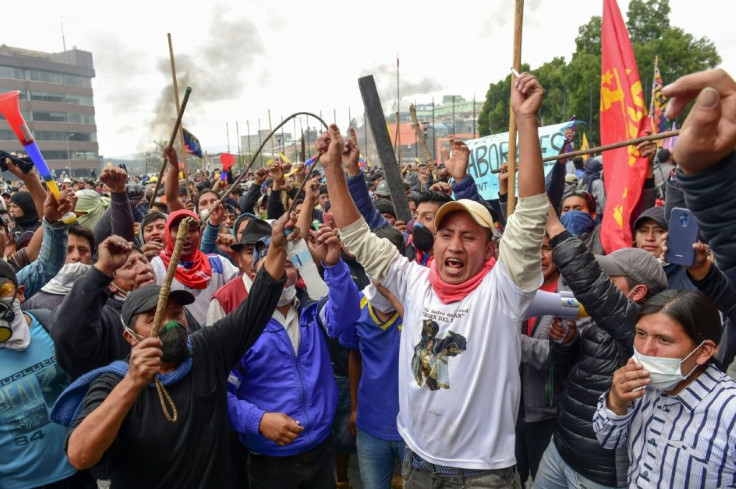 Angry demonstrators shout slogans outside the national assembly in Quito during clashes Tuesday with security forces