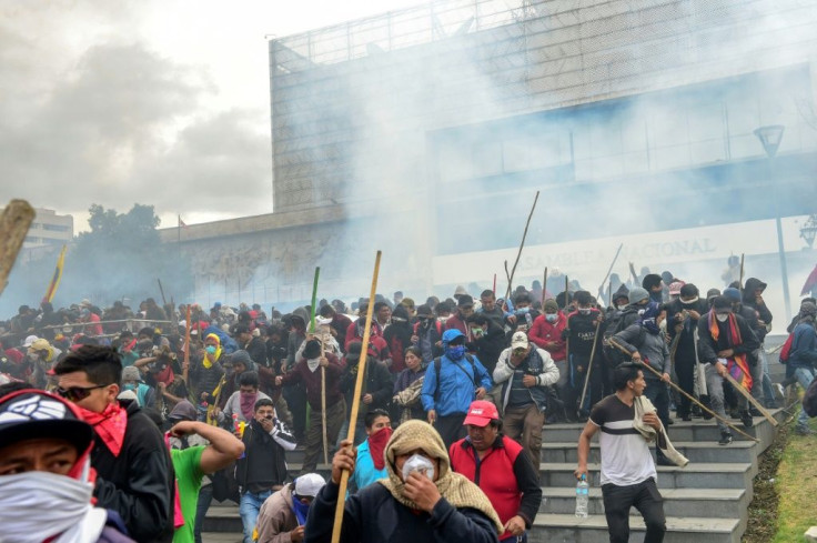 Demonstrators are dispersed away from the national assembly by riot police using tear gas, in Quito on October 8, 2019
