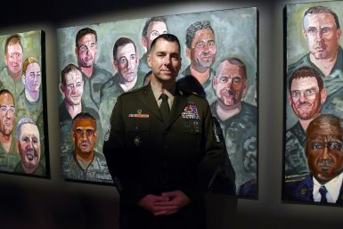 Command Sergeant Major Brian Flom, pictured next to a painting of himself by former president George W. Bush, was wounded in the face by a rocket attack in Iraq in 2007