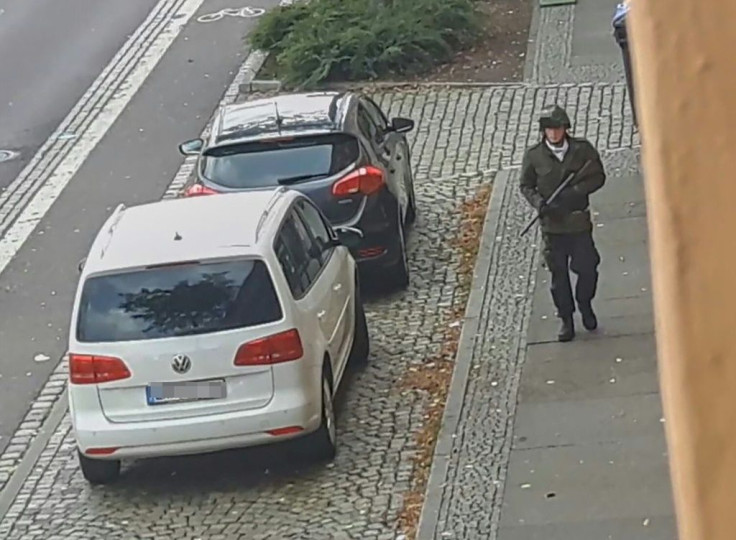 A screenshot taken from a video by ATV-Studio Halle shows a man walking with a gun in the streets of Halle