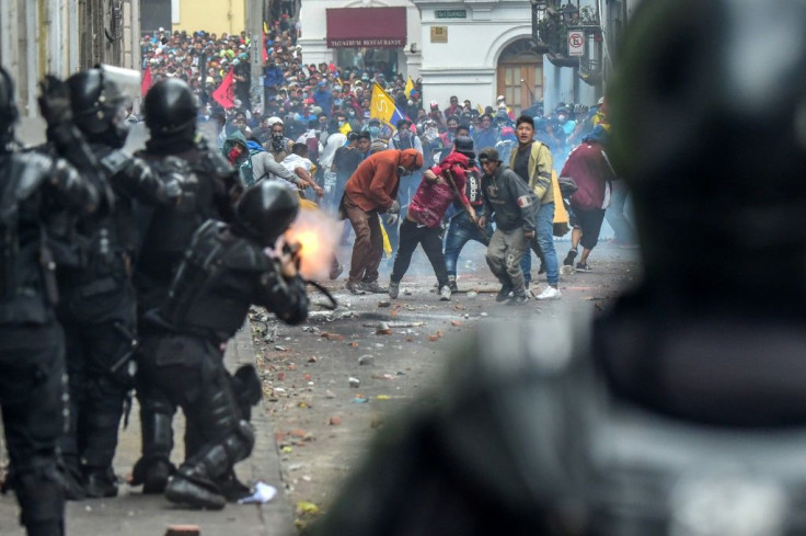 Demonstrators clash with riot police as thousands march against Ecuadorean President Lenin Moreno's decision to slash fuel subsidies, in Quito on October 9, 2019