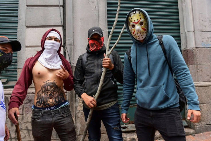 Demonstrators pose for a picture during clashes with riot police in Quito