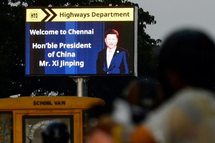 Commuters drive past a sign welcoming China's President Xi Jinping in Chennai, India, ahead of a summit with his Indian counterpart Narendra Modi while the Kashmir issue places the two countries' ties under increased strain