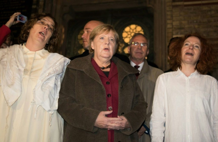 German Chancellor Angela Merkel sings with members of the Jewish community at a vigil outside Berlin's main synagogue