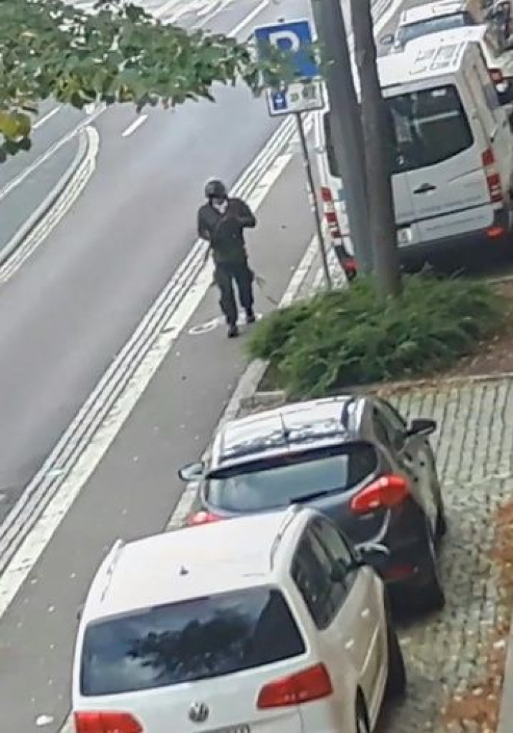 In this screenshot taken from a video by ATV-Studio Halle, a man walks with a gun in the streets of Halle an der Saale in eastern Germany at the time of a deadly shooting at a synagogue and restaurant