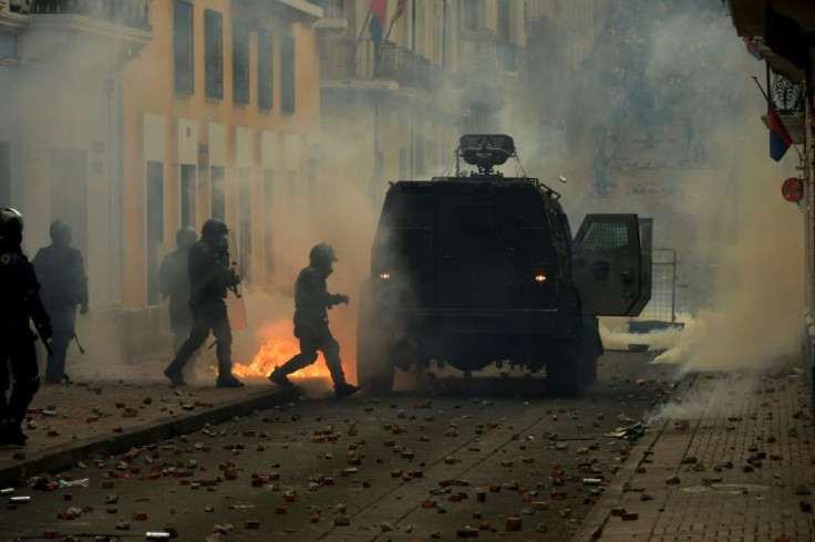Riot police confront demonstrators during clashes in Quito