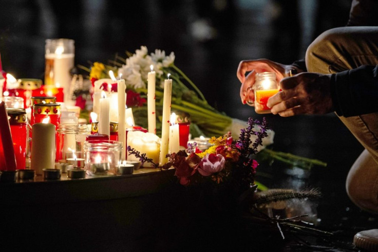 People leave candles and flowers at a vigil at the Marktplatz in Halle, eastern Germany