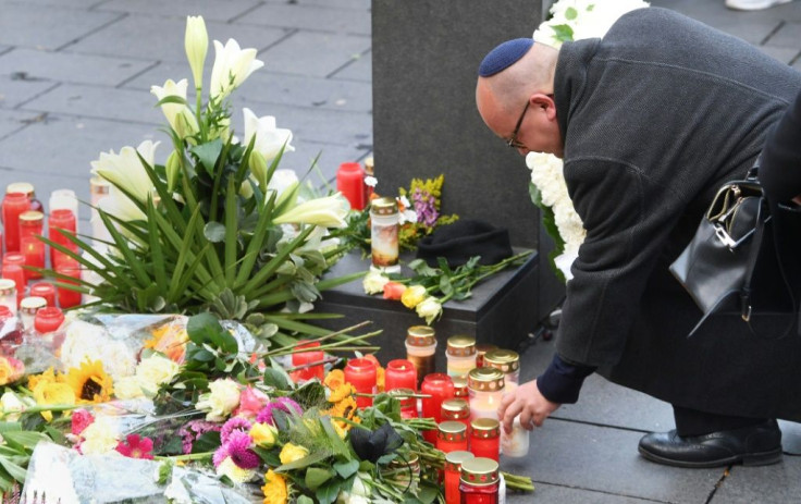A man wearing a kippah skullcap places a candle at a makeshift memorial a day after two people were shot dead as Halle's Jewish community marked Yom Kippur