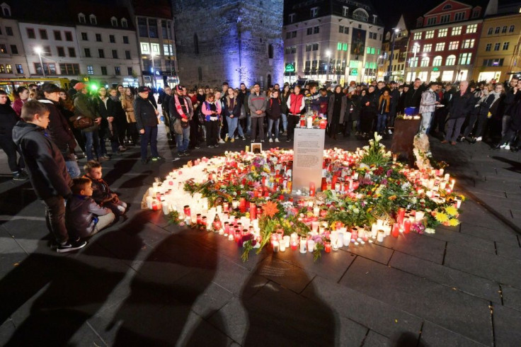 Mourners paid their respects to the victims at a makeshift memorial of flowers and candles at the market square in Halle the day after the attack