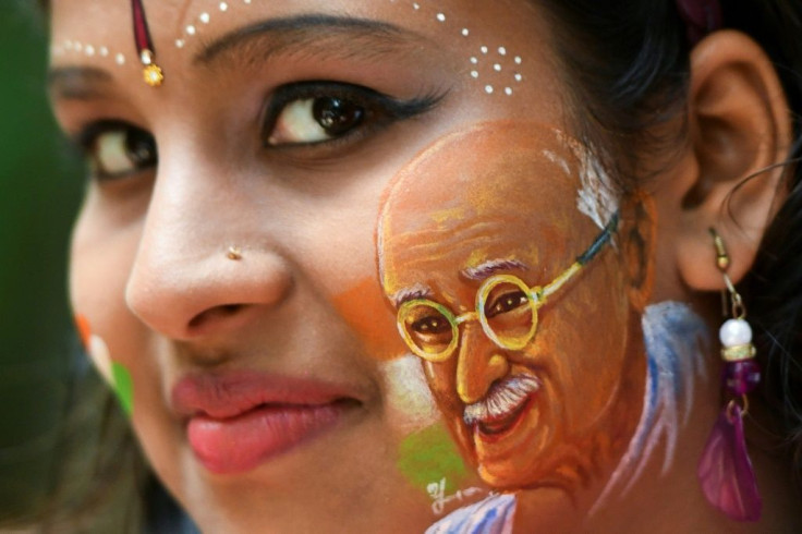 Britain will commission a commemorative coin to mark the 90th anniversary of the final visit by Indian independence hero Mahatma Gandhi; a girl poses for a picture, August 15, 2019, with her face painted depicting a portrait of Mahatma Gandhi