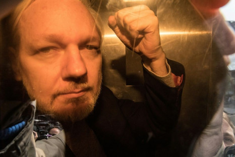 WikiLeaks founder Julian Assange gestures from a police van in May. He has now been ordered to appear in court in person for a hearing on October 21. violation.