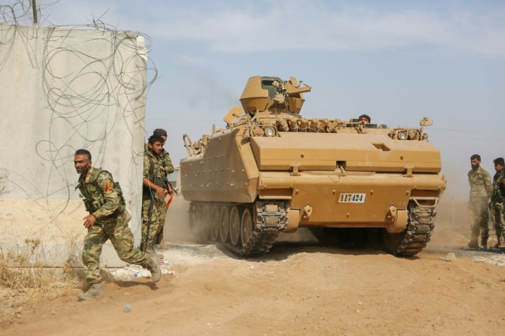 Pro-Turkish Syrian fighters drive an armoured personnel carrier across the border into Syria as they take part in an offensive against Kurdish-controlled areas in northeastern Syria launched by the Turkish military, on October 11, 2019