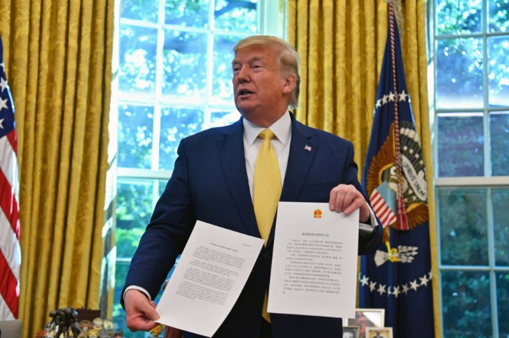 US President Donald Trump shows a letter from Chinese President Xi Jinping as he announces and initial deal with China while meeting the special Envoy and Vice Premier of the People's Republic of China Liu He Special Envoy and Vice Premier of the People's
