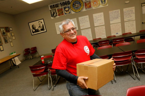 Louis Rocha, president of the UAW Local 5960, carries a box of food supplies for a striking worker on October 11 in Lake Orion, Michigan