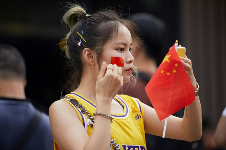 Many spectators at a pre-season game between the Los Angeles Lakers and the Brooklyn Nets in Shenzhen put Chinese flag stickers over their shirts' NBA logo, or held small Chinese flags