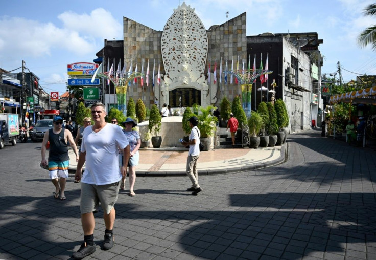 Foreign tourists visit a memorial for victims of the 2002 Bali bombings in the Kuta tourist strip near Denpasar on Indonesia's resort island of Bali, where some victims' family members broke down in tears 17 years after the attacks