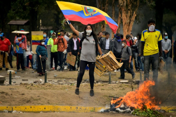 A demonstrator waves an Ecuadoran flag during clashes with riot police amid protests over a fuel price hike ordered by the government to secure an IMF loan on October 12, 2019