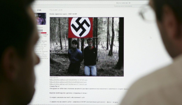 Two men look at the website of the United Slavic National-Socialists Forum on a computer in Moscow in 2007 which contained a video apparently executing a Tadjik national and an ethnic Dagestani man in a forest with a Nazi flag in the background.