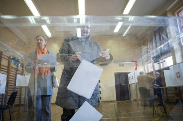 A woman casts her ballot at a polling station in Warsaw in the parliamentary elections the ruling populist government is expected to win