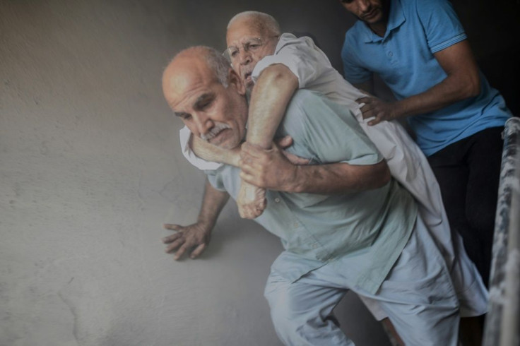 An elderly man is evacuated from a building in the Turkish border town of Akcakale after it was hit by a rocket reportedly fired from Syria