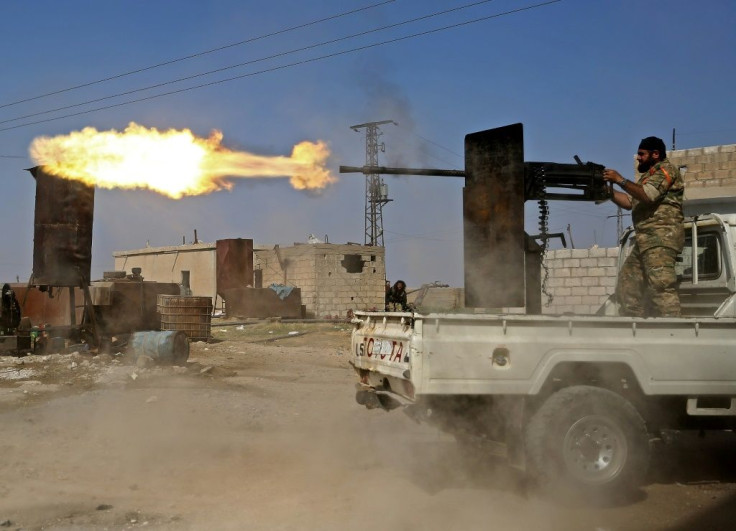 A Turkish-backed Syrian fighter fires during clashes in the border town of Ras al-Ain